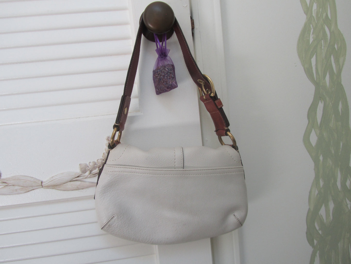 Light gray handbag with a brown strap on a white background