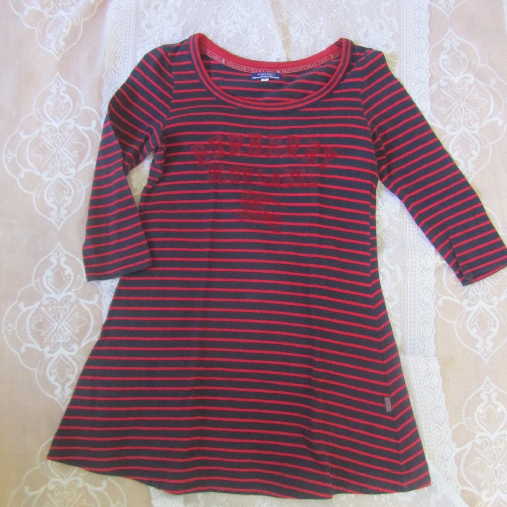Red and black striped shirt on a textured white surface