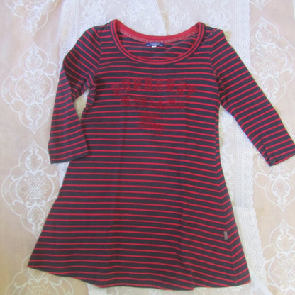 Red and black striped shirt on a textured white surface