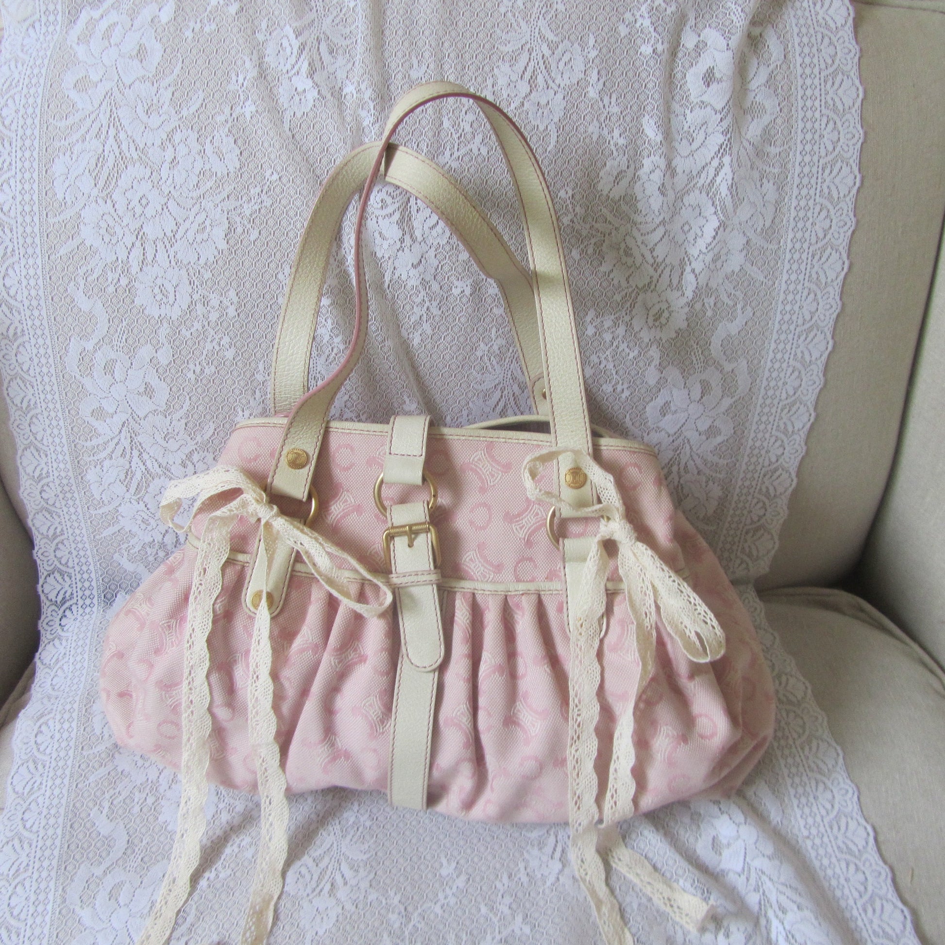 Pink handbag with lace details on a white lace background