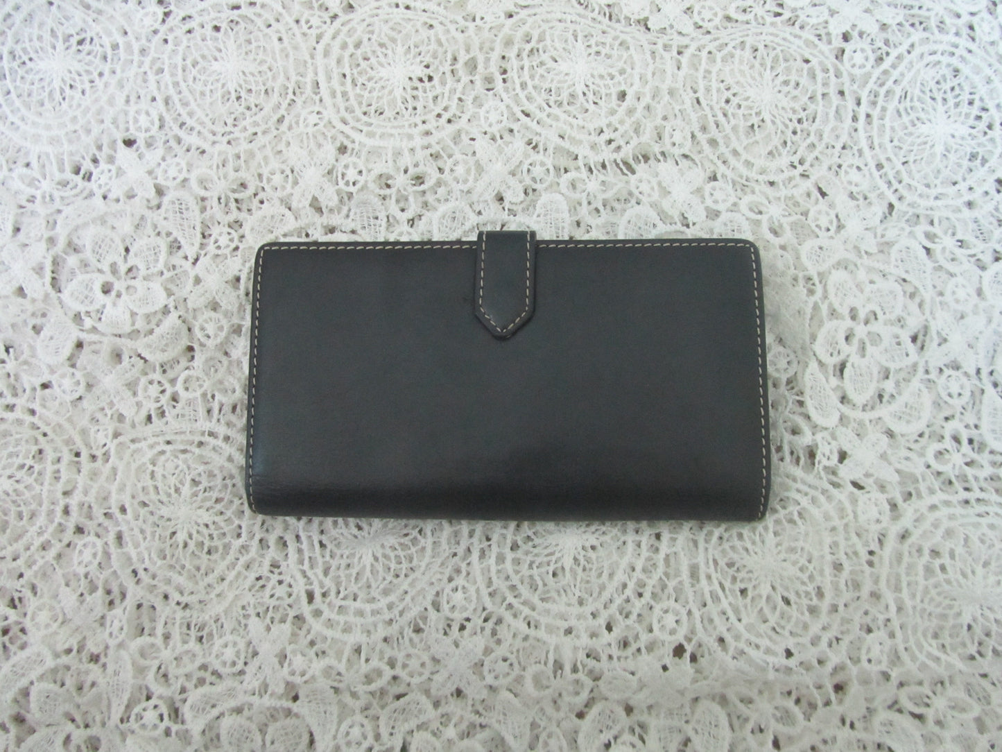 Black wallet on a white lace background