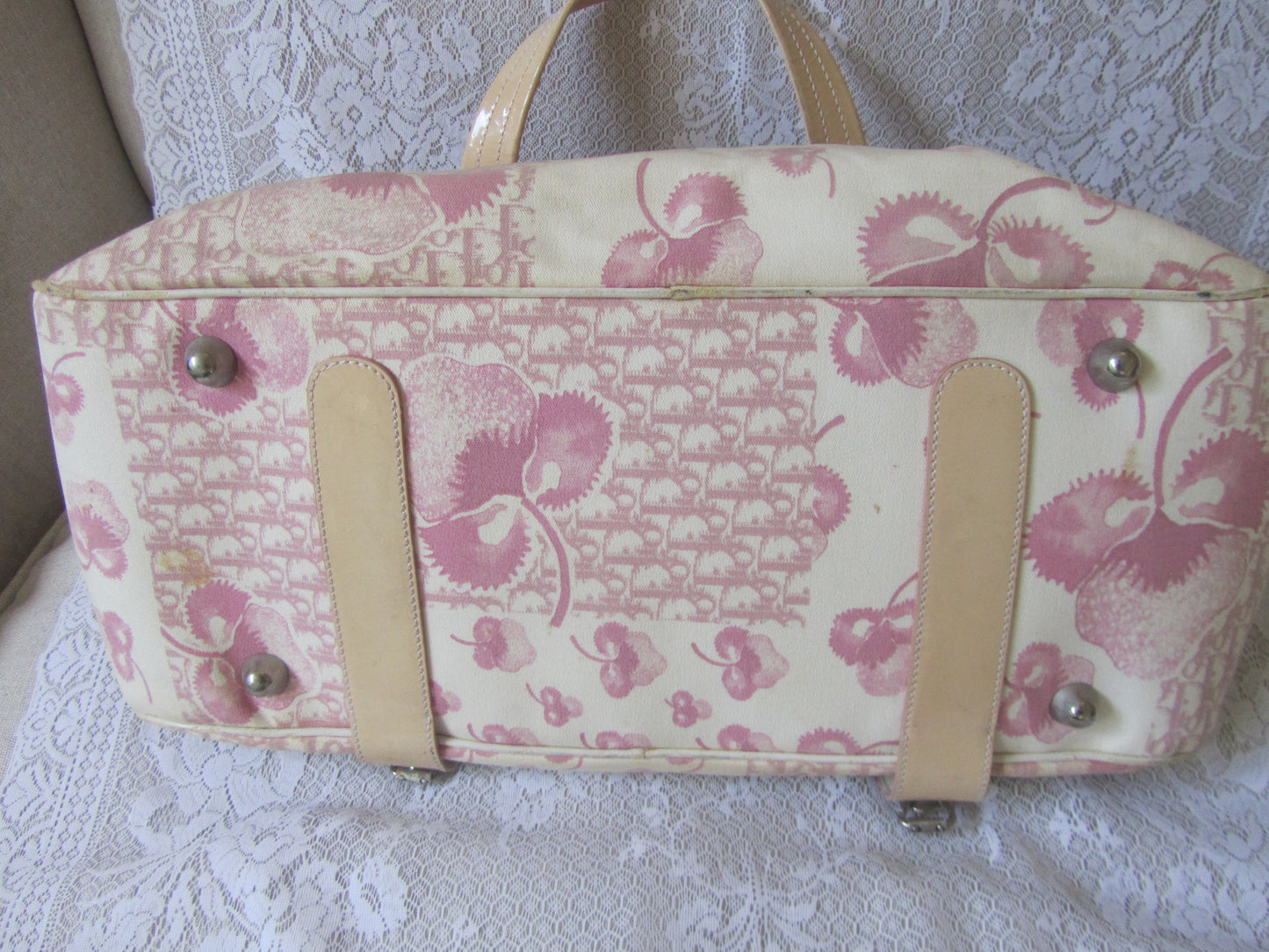 Floral patterned handbag with beige straps on a lace background