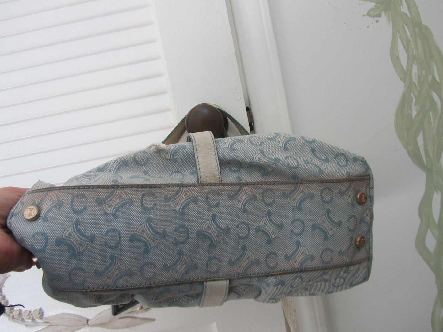 Patterned bag held by a hand against a white background
