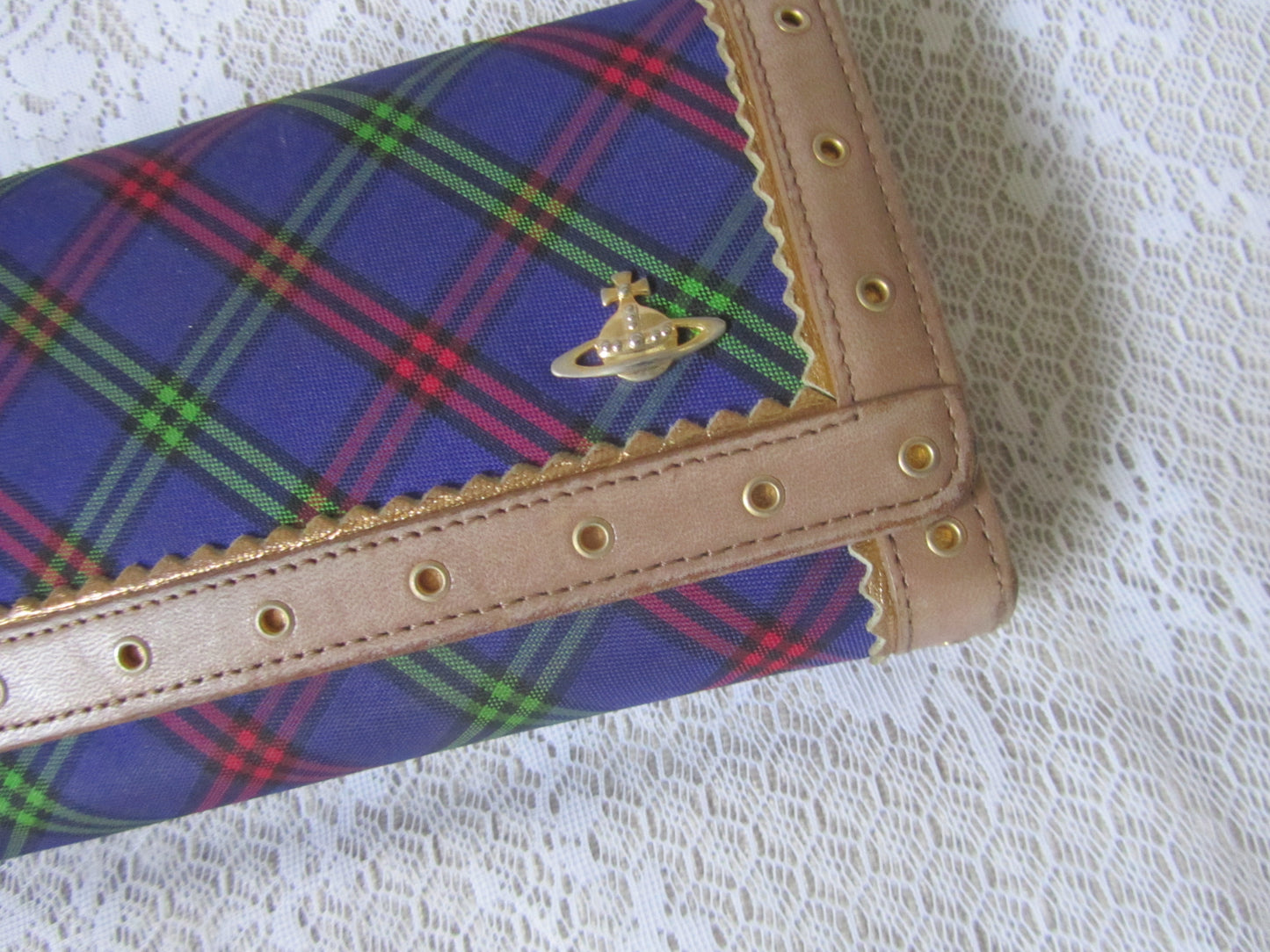 Plaid wallet with visible brand logo on a textured white background
