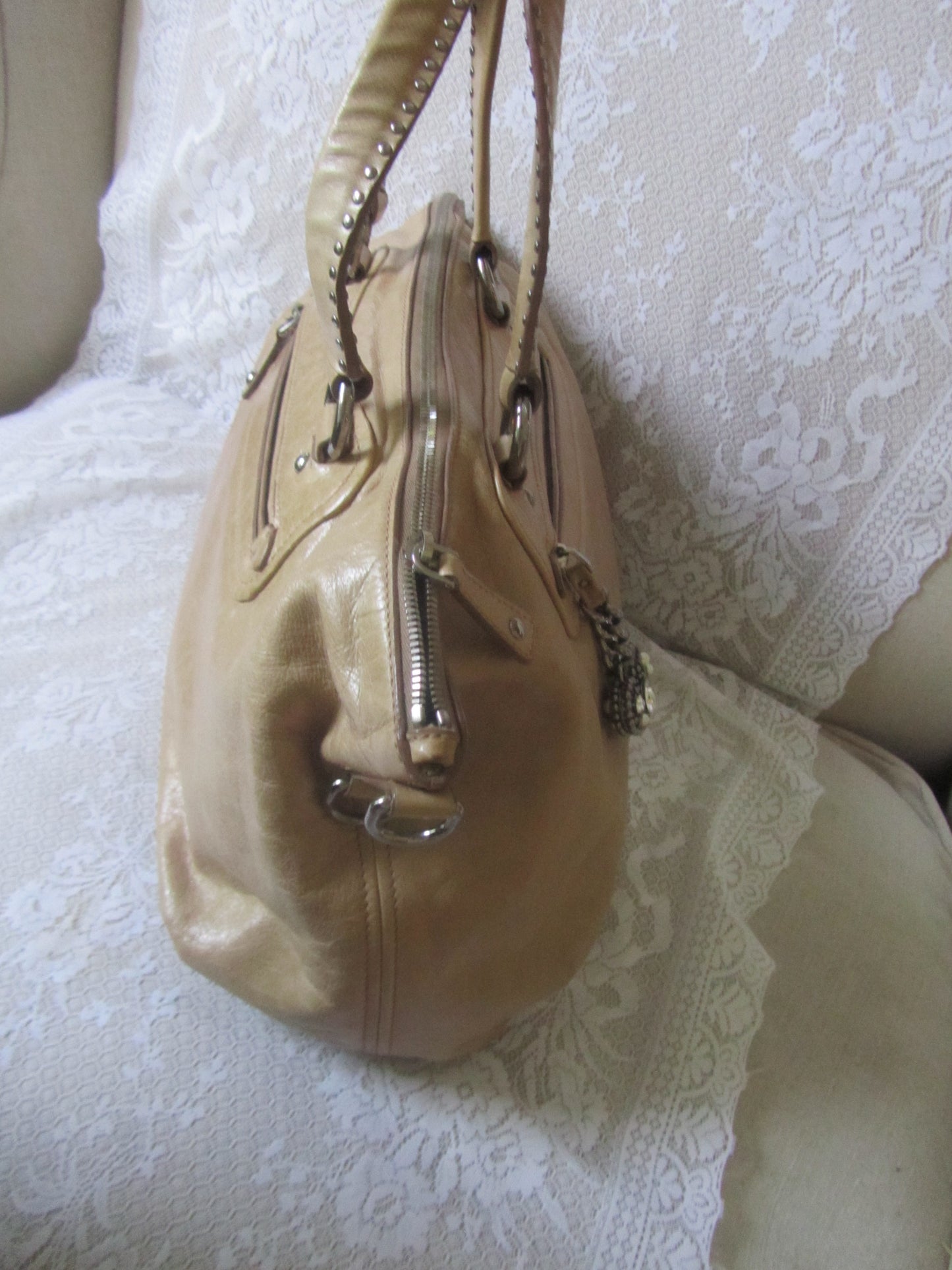 Beige handbag on a white lace fabric background