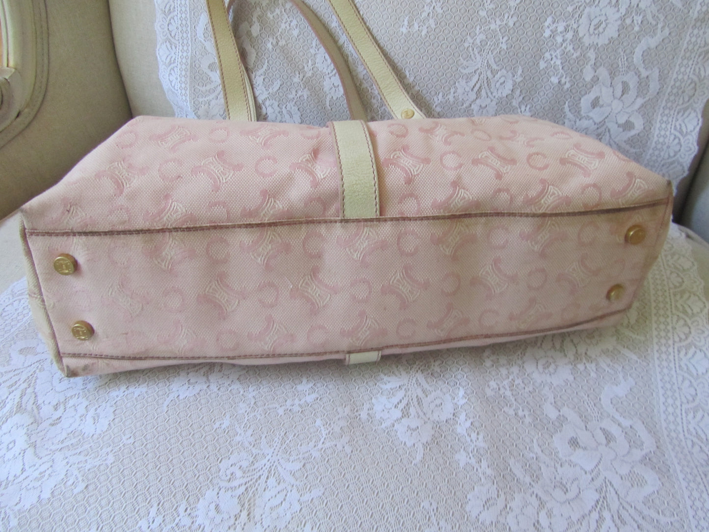 Pink handbag with gold accents on a textured surface