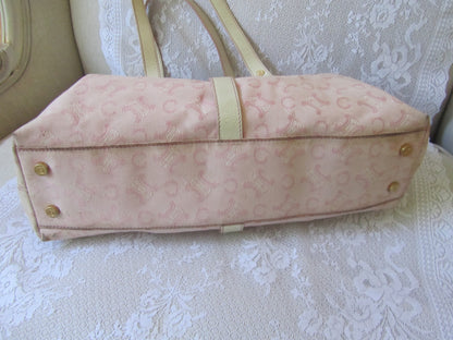 Pink handbag with gold accents on a textured surface