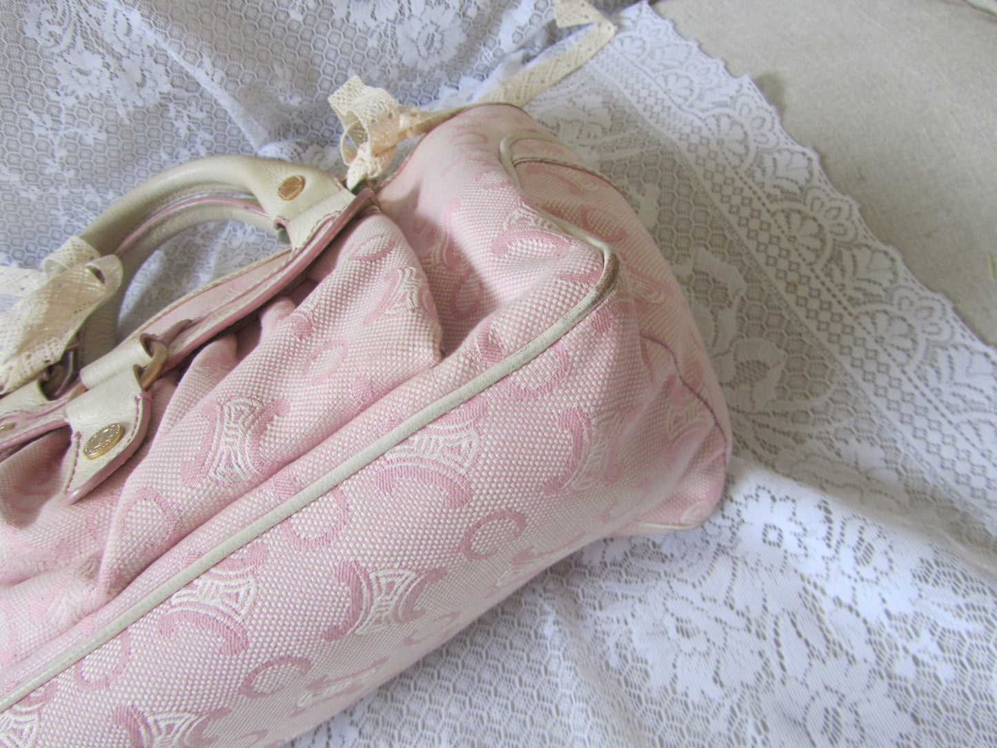 Pink bag with a bow on a lace surface