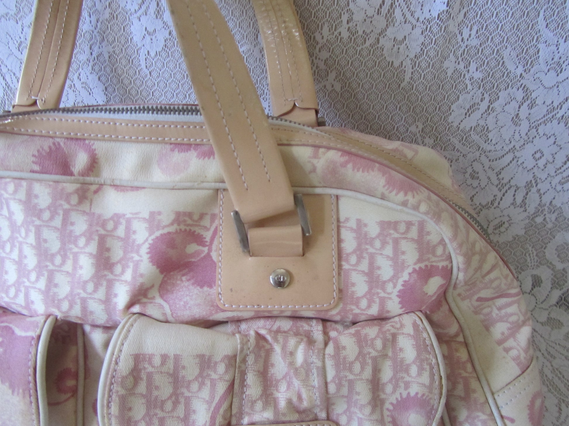 Patterned handbag with a beige strap against a textured white background