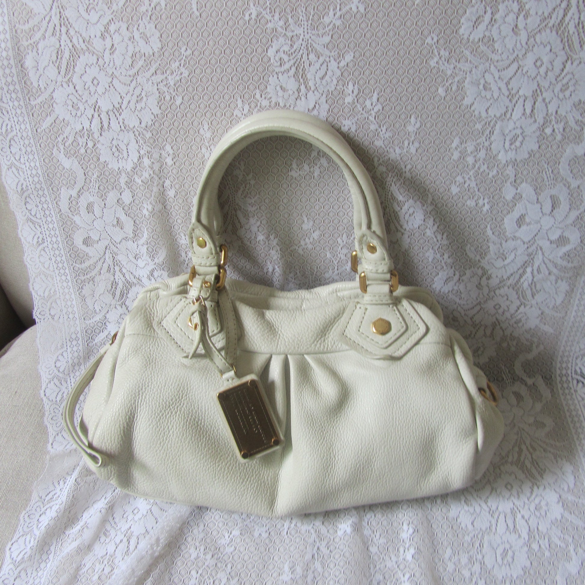 White handbag on a textured white surface
