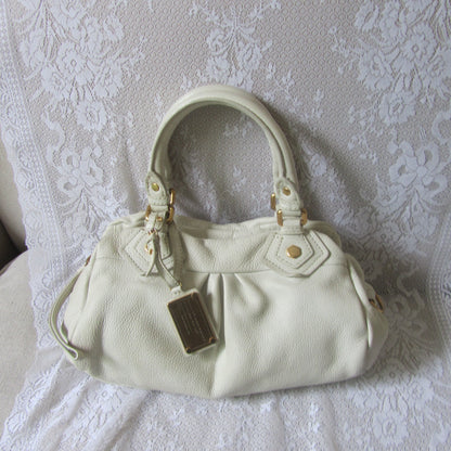 White handbag on a textured white surface