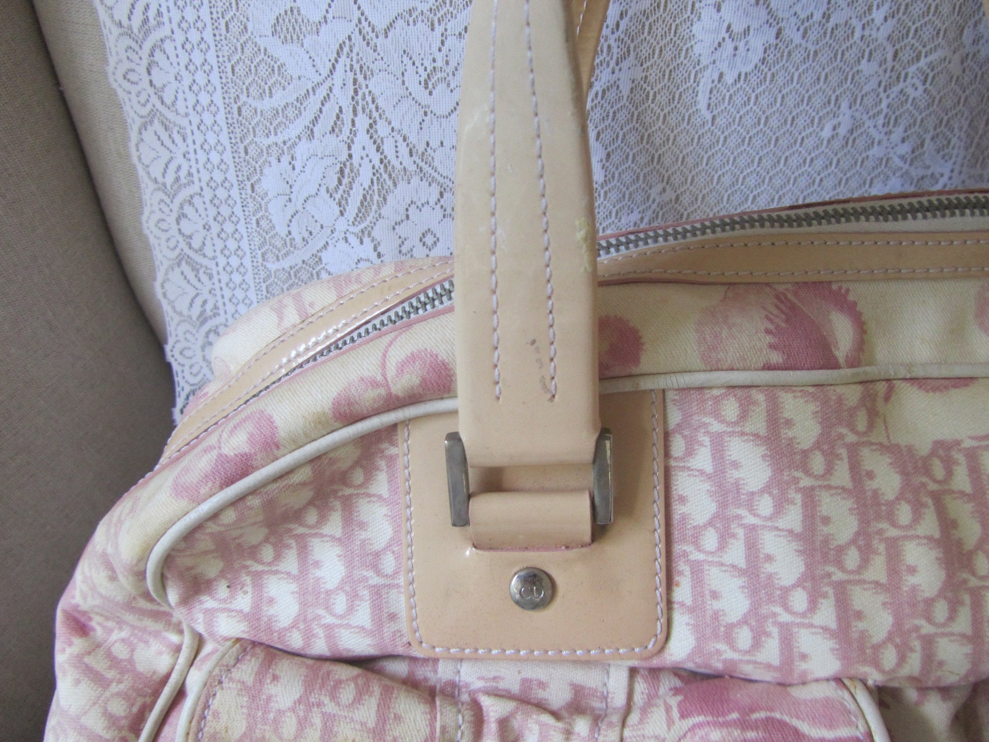Pink patterned bag with beige strap on a textured white background
