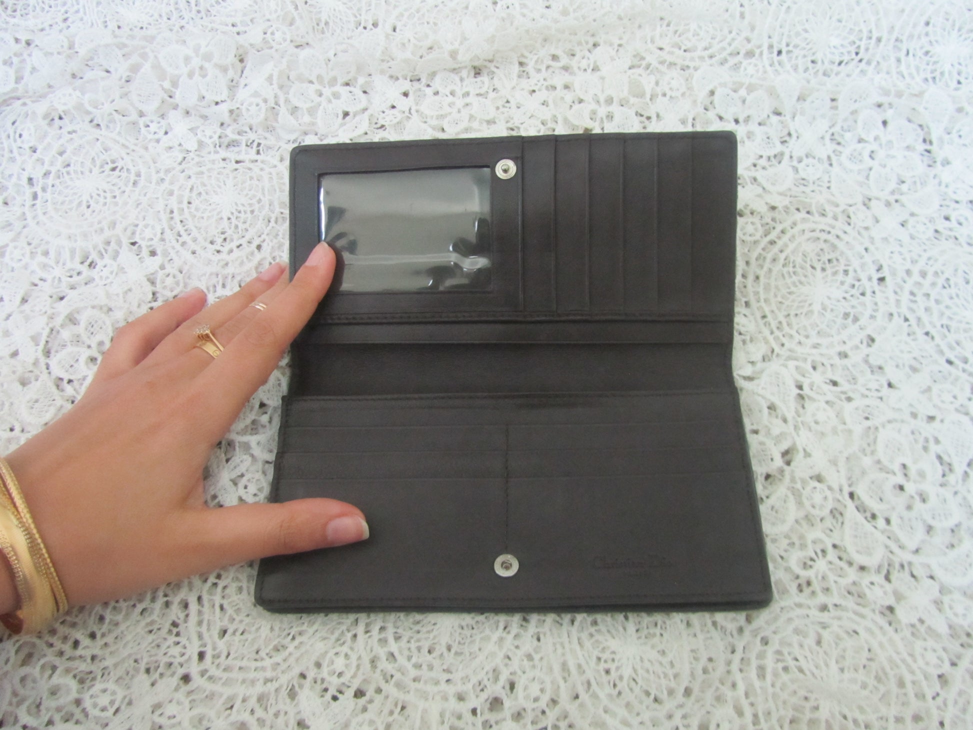 wallet on a textured white surface with a hand touching it