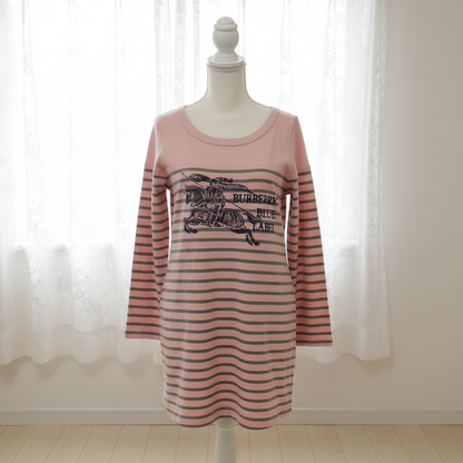 Pink and black striped dress with Burberry logo on a mannequin against a white curtain background