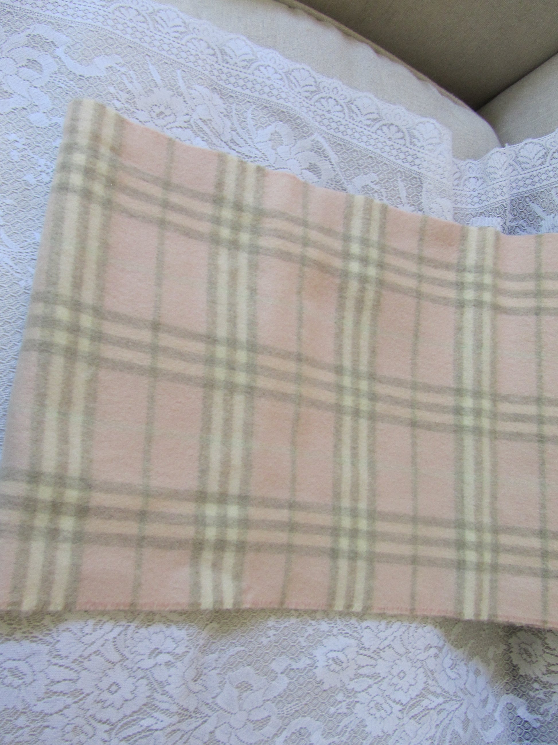 Plaid scarf with a brand label on a textured white surface