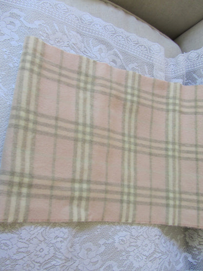 Plaid scarf with a brand label on a textured white surface