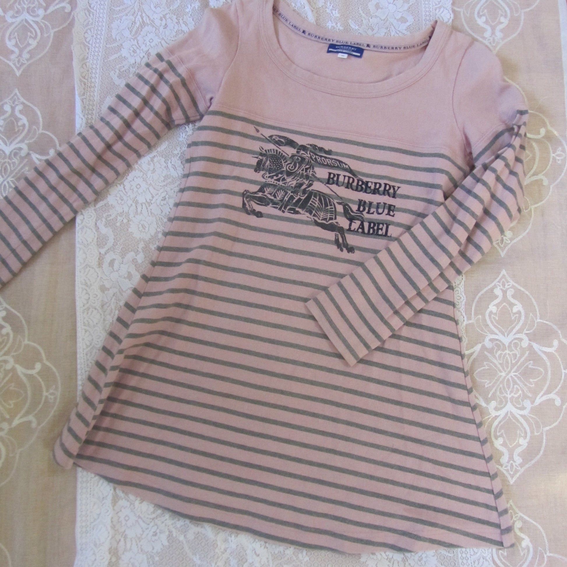 Striped long-sleeve shirt with brand logo on a patterned surface
