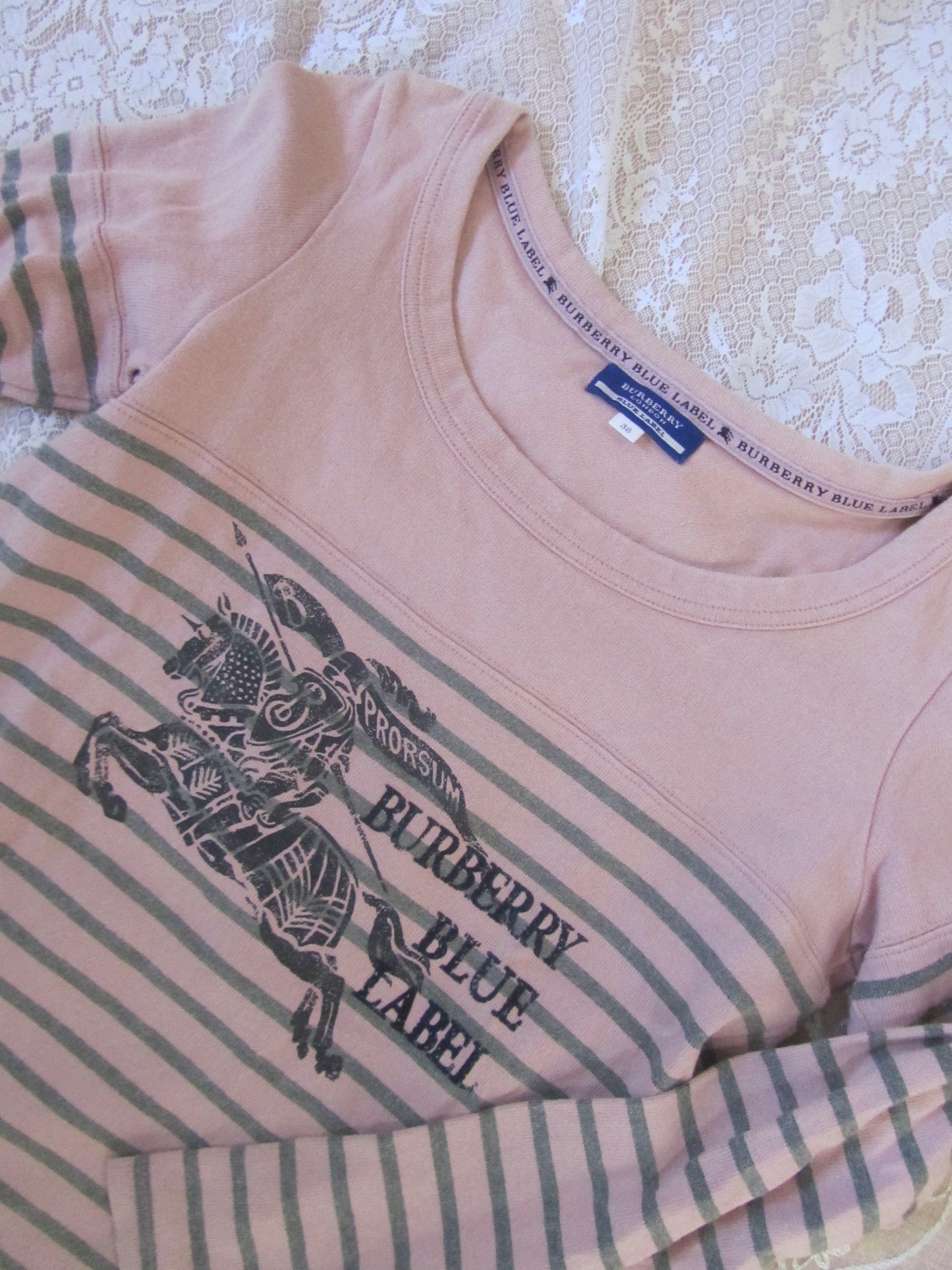 Pink and green striped shirt with Burberry Blue Label logo on a textured surface