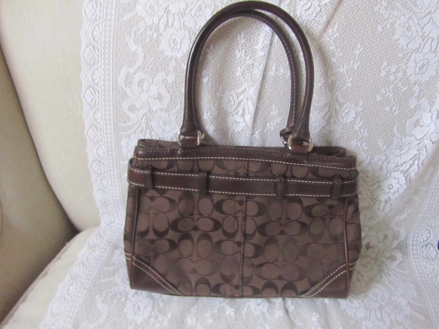 Brown handbag with a pattern on a textured white surface