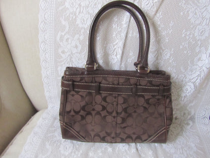 Brown handbag with a pattern on a textured white surface