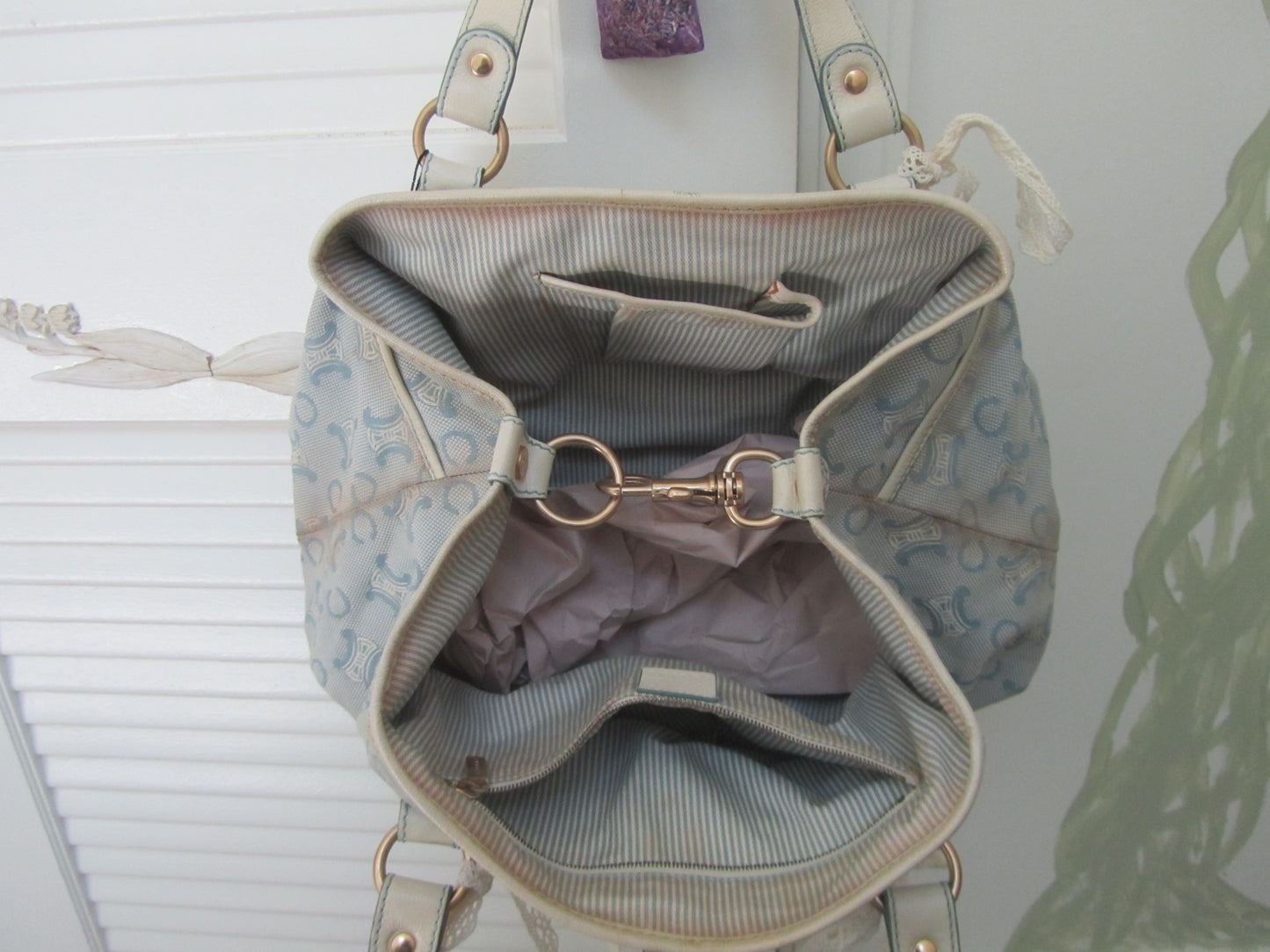 Light blue handbag with gold accents on a white background