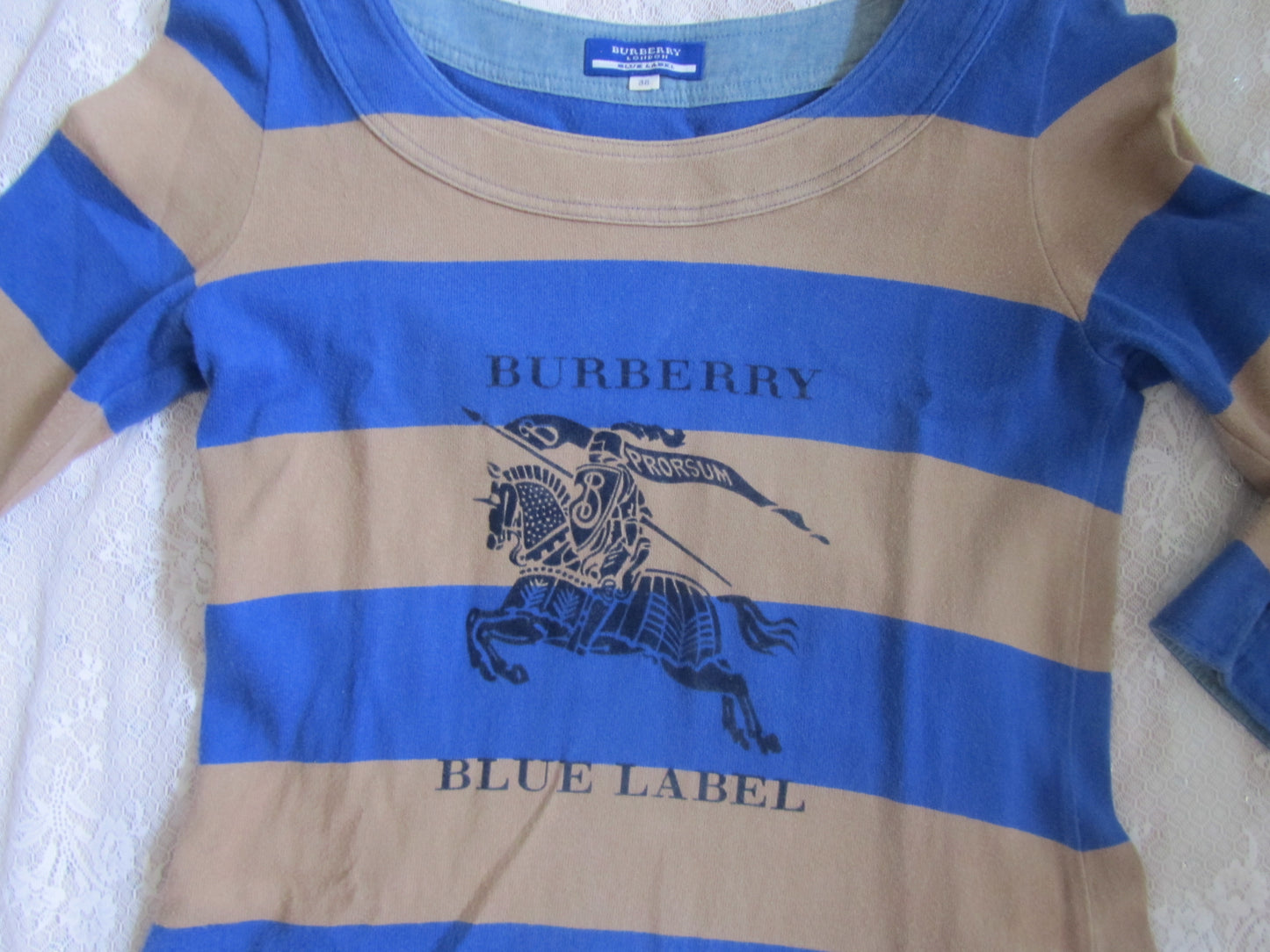 Burberry shirt with blue and beige stripes on a textured surface