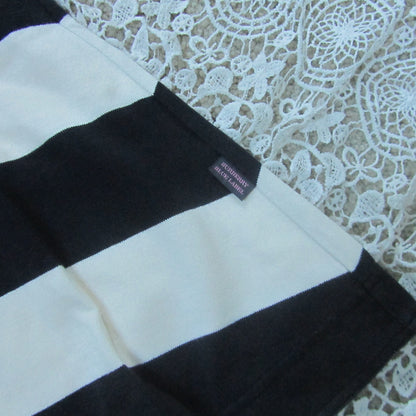 Black and white striped fabric with a brand label on a lace background