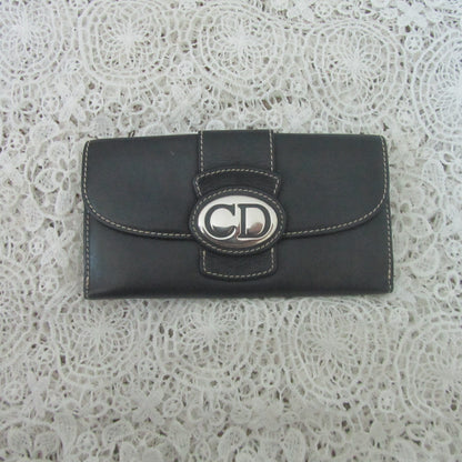Black wallet with a brand logo on a textured white background