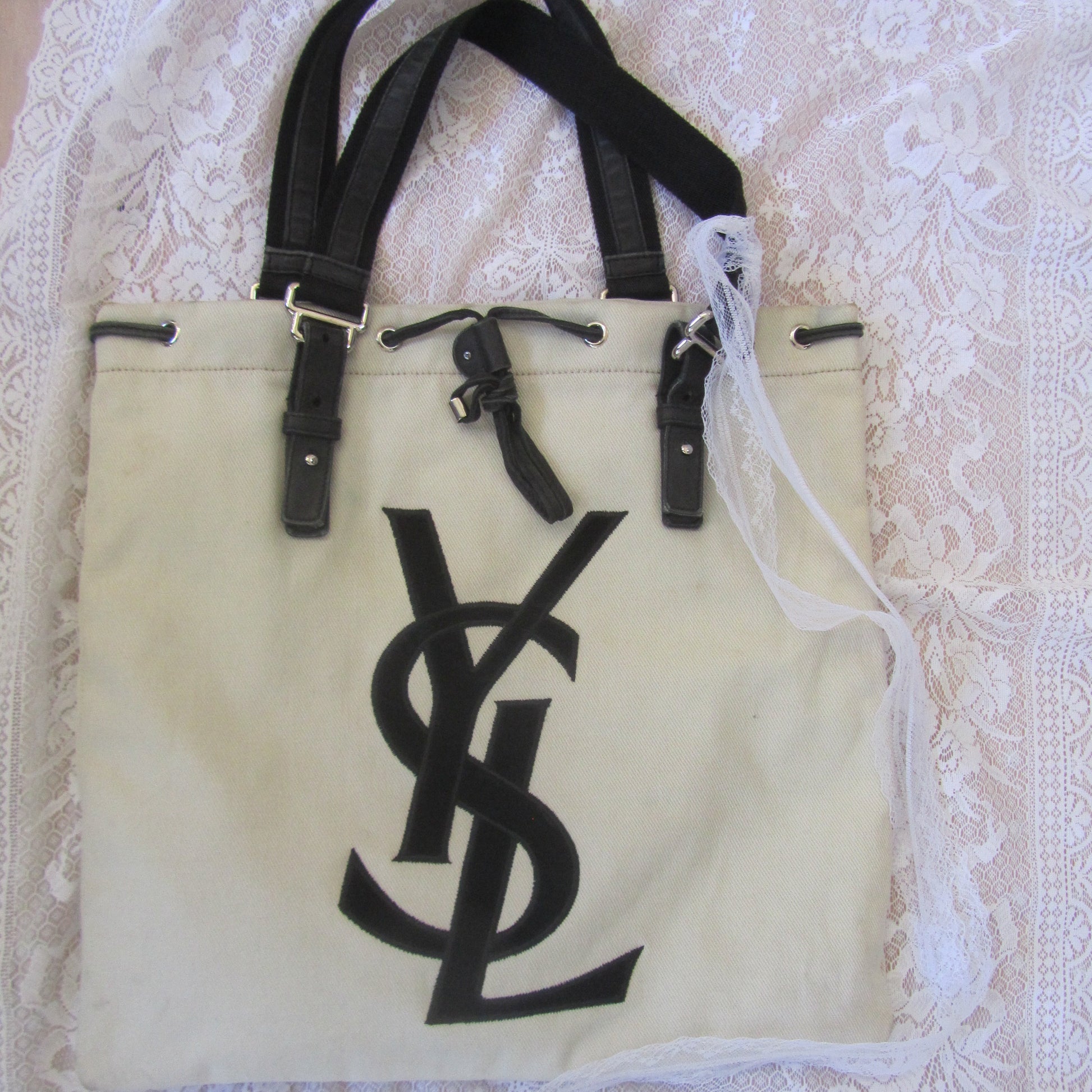 Beige bag with black logo on a textured white background