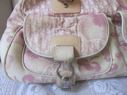 Pink and beige patterned handbag on a lace surface