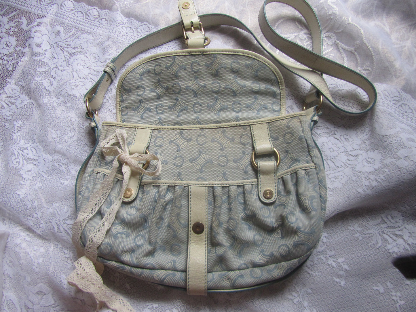 Light blue handbag with beige accents on a textured white background