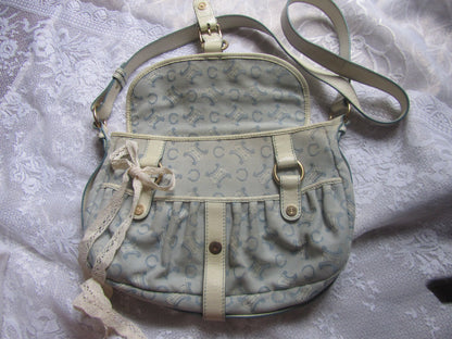 Light blue handbag with beige accents on a textured white background