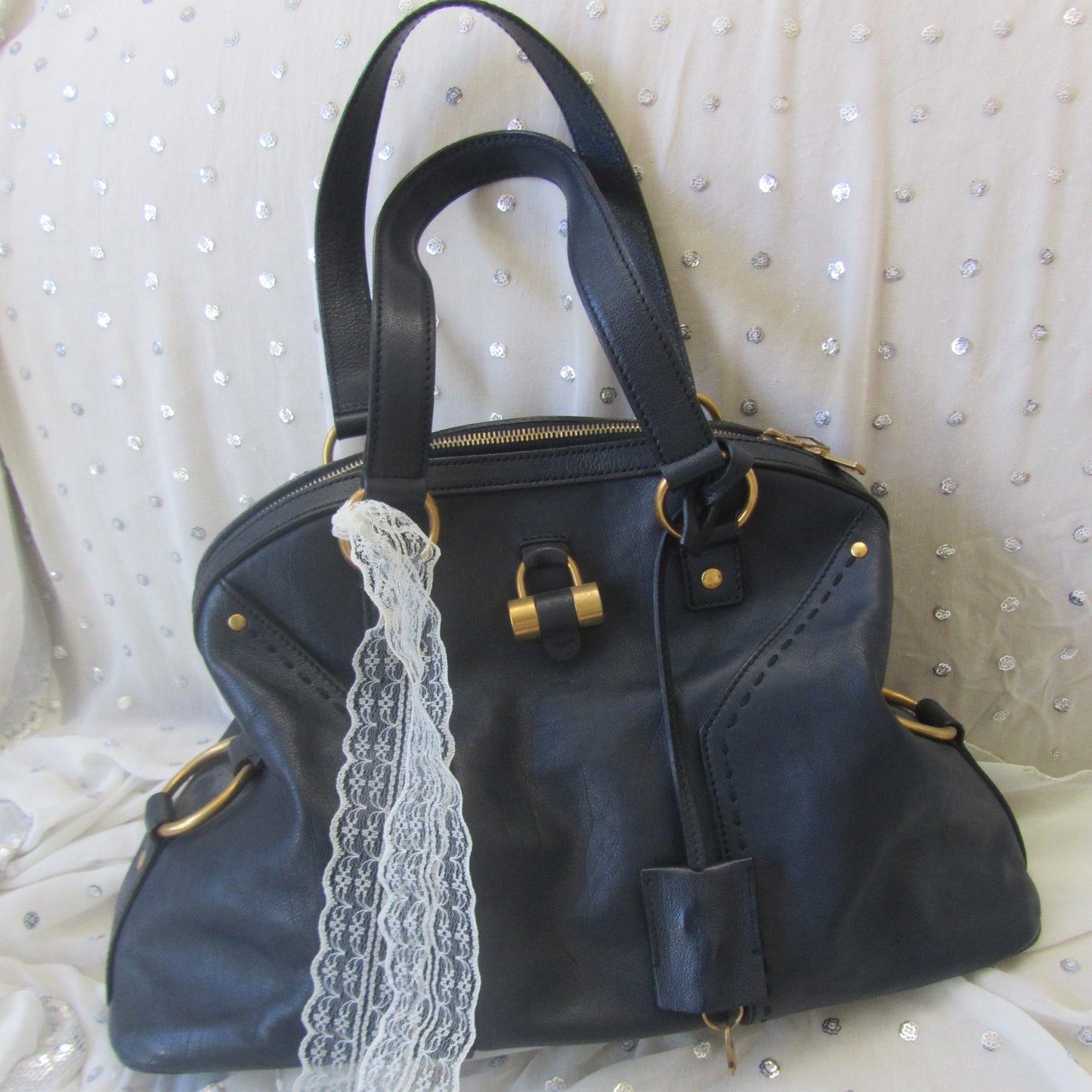 handbag with gold accents on a white textured surface