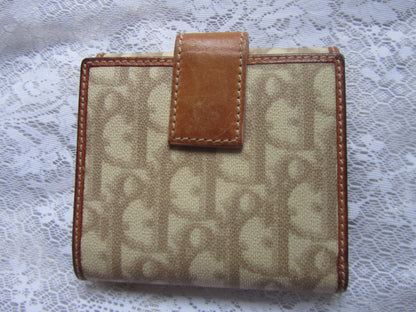 Beige wallet with brown leather accents on a lace background
