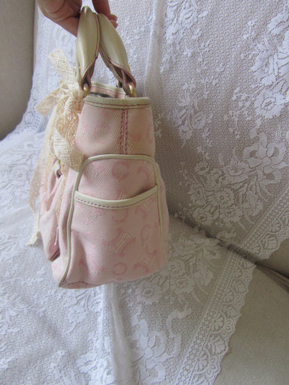 Pink patterned bag on a textured white surface
