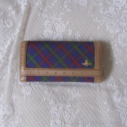 Plaid wallet with brand logo on a textured white surface