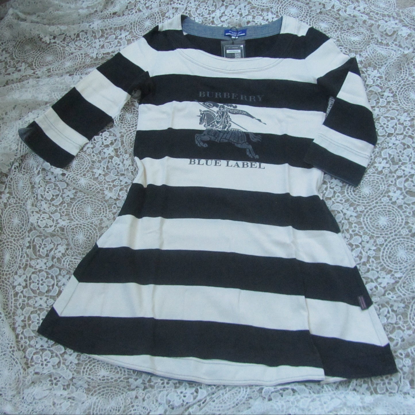 Black and white striped dress with Burberry label on a textured surface