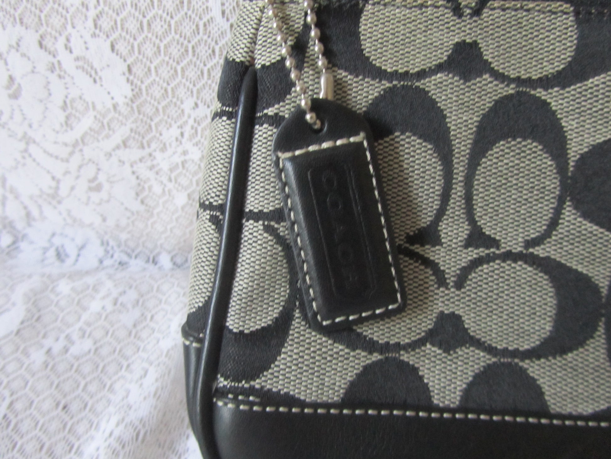 Patterned handbag with a visible brand tag on a textured white background