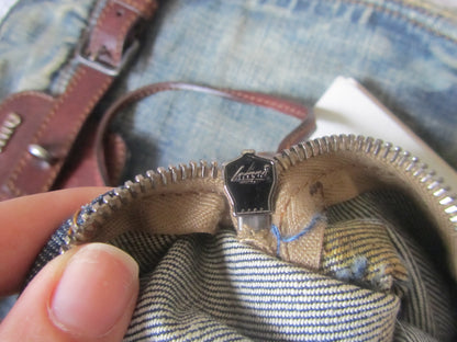 Close-up of a zipper on a piece of clothing with a brand logo.