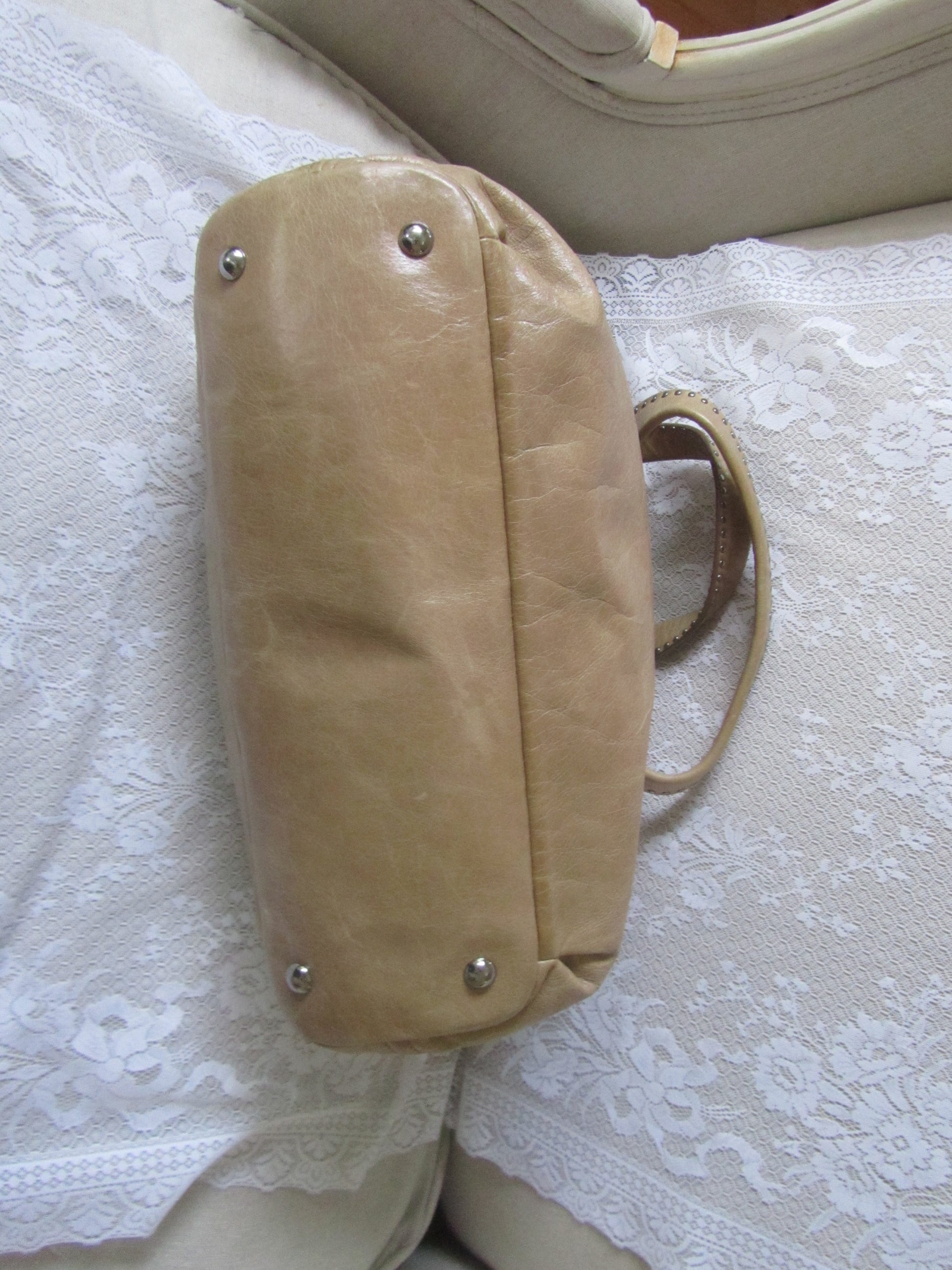 Beige handbag on a textured white surface