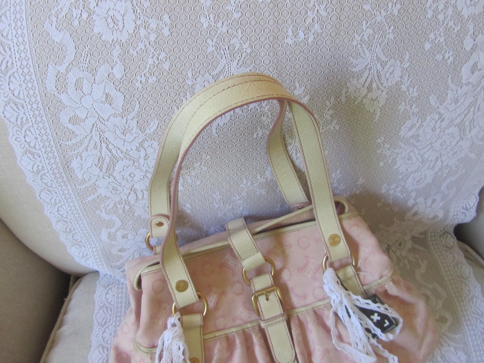 Pink handbag with gold straps on a textured white background