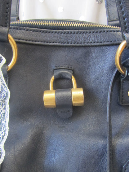 Close-up of a black leather bag with gold hardware