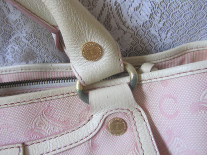 Close-up of a pink handbag with gold hardware on a lace background