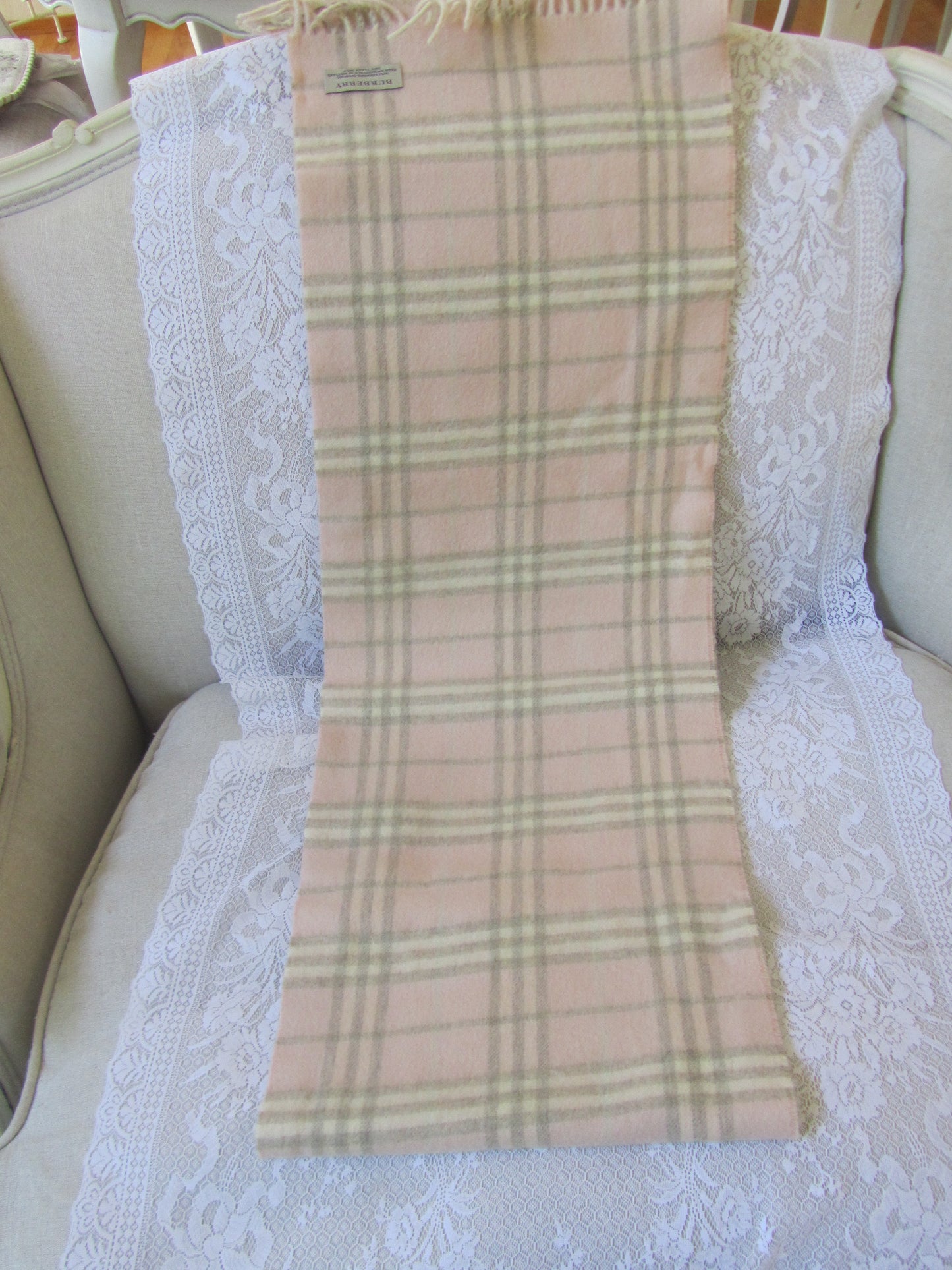 Plaid scarf with a brand label on a textured white surface