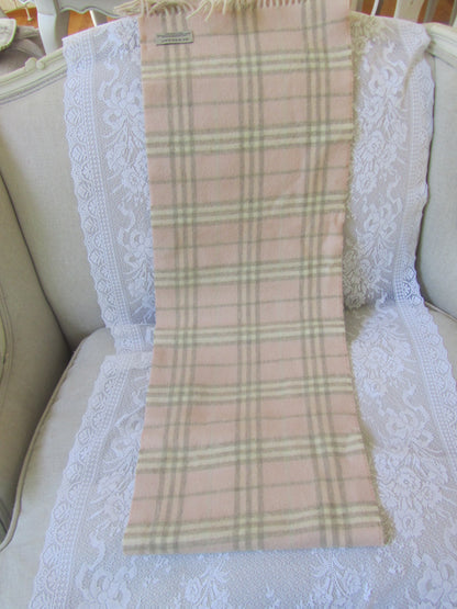 Plaid scarf with a brand label on a textured white surface
