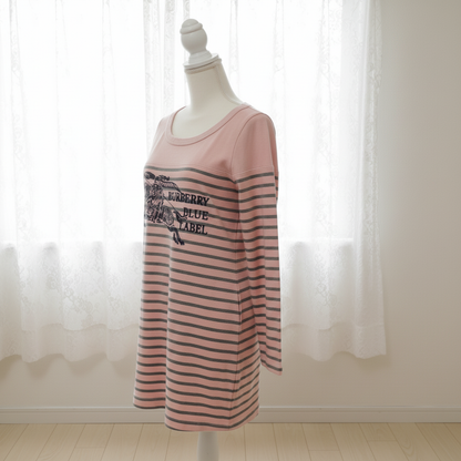 Pink and black striped dress on a mannequin against a white curtain background
