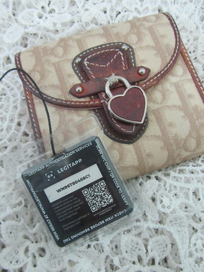 Beige leather wallet with brown accents on a white lace background