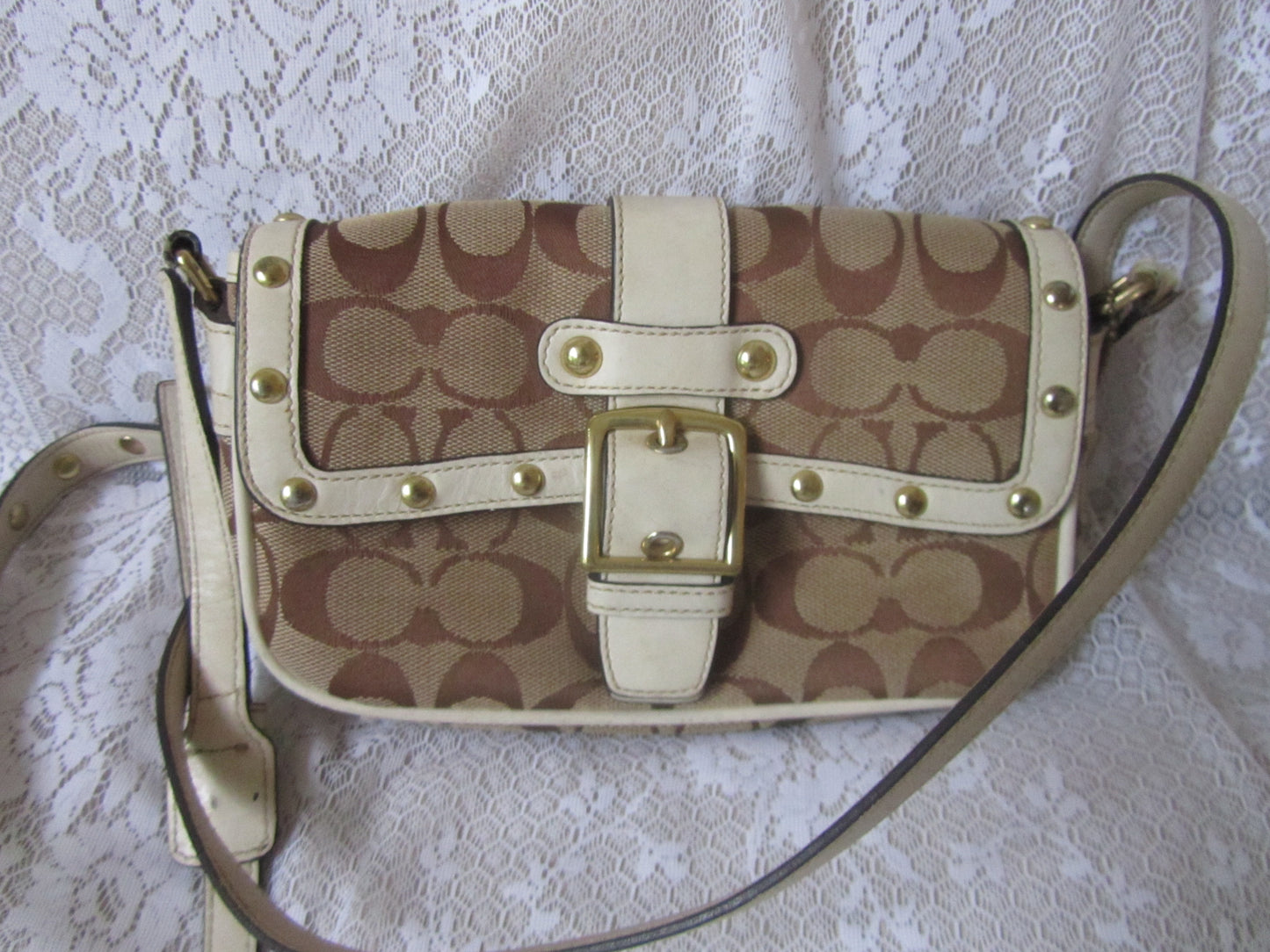 Patterned handbag with gold accents on a textured white background