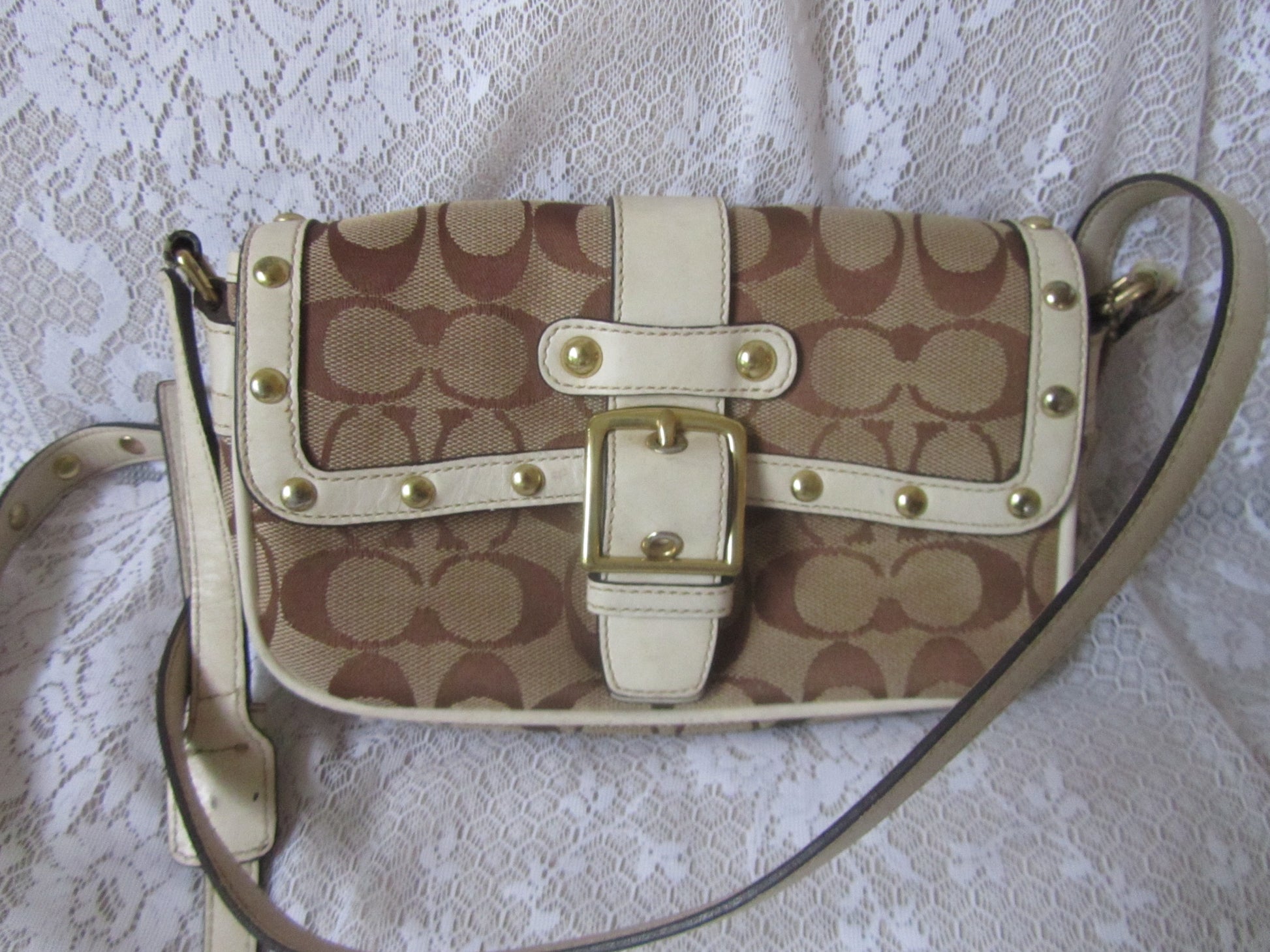 Patterned handbag with gold accents on a textured white background