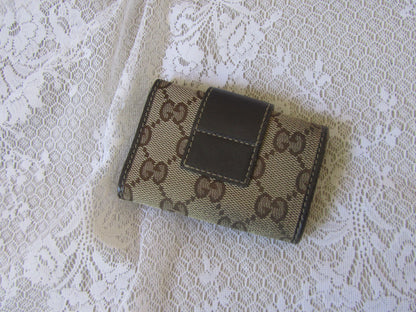 Small wallet with brand logo on a lace fabric background